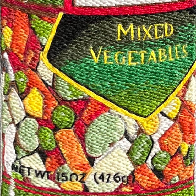 A close-up of the vegetables and some of the words on the can showcasing mostly brick stitch. 
