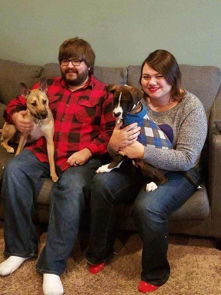 A picture of two people with a dog sitting on each of their laps. 

This was the family picture the rescue took when Bo came home to us ❤️