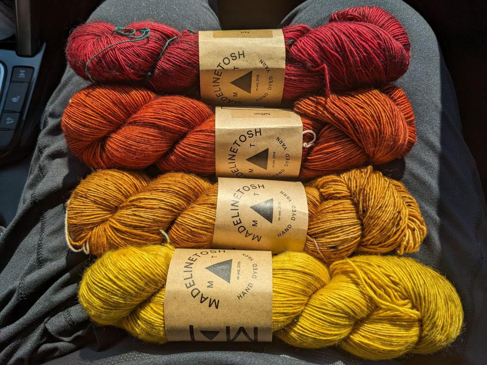 A selection of yarns from yellow to red.