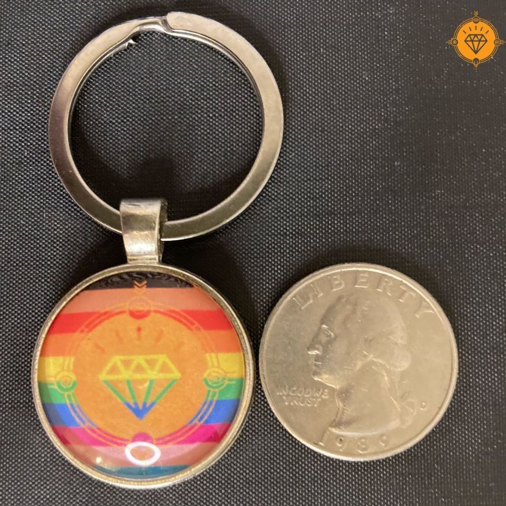 Rainbow medallion on keychain is slightly bigger than a quarter. Design includes our genital seal against the rainbow background.