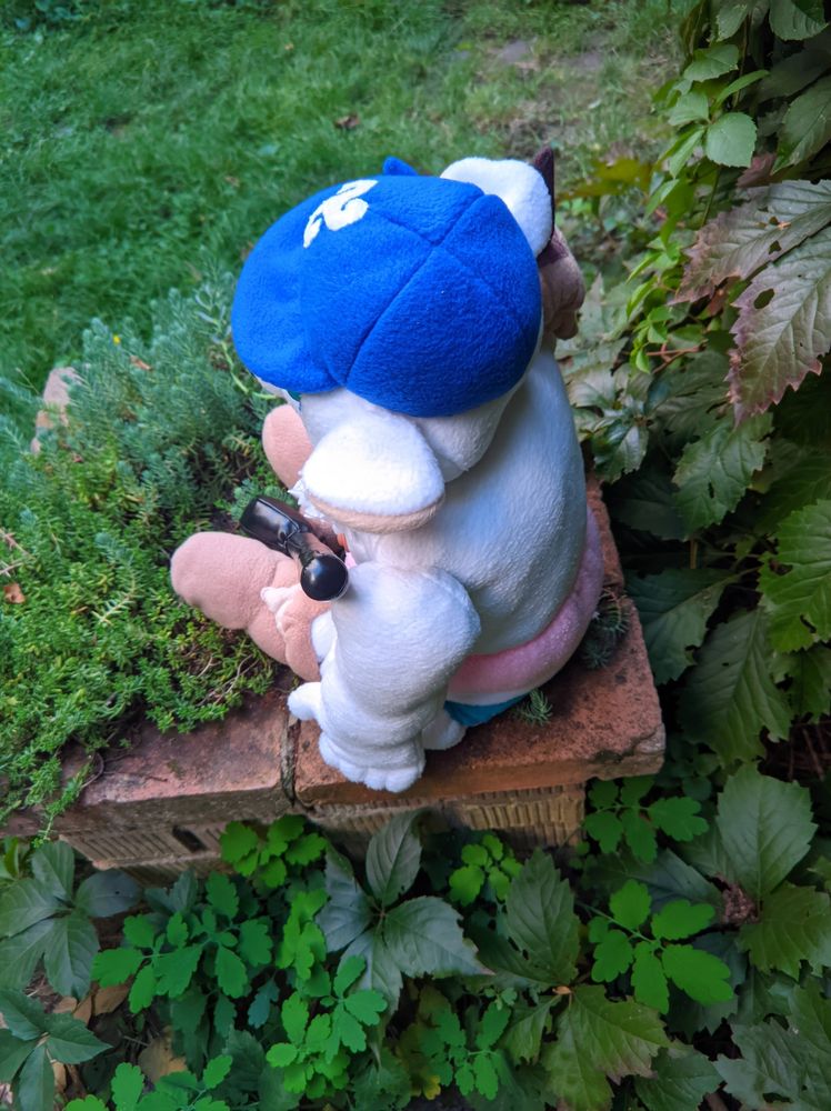 Handmade one of a kind custom Volibear plush, inspired by League of Legends champion. He is wearing a "Cloud9 e-sports team logo" cap, has a furry mane, spiky shoulder piece, "Texas Longhorns football team logo" cowboy boots and striped pink, white, blue underpants. Holding a golf club in his hand. Topless. View from bihind.