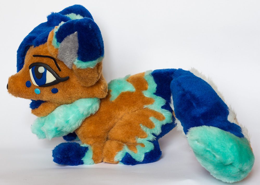 Handmade one-of-a-kind plush, inspired by an original character, looking like a colorful fennec fox with a long deep blue bangs and freckles 