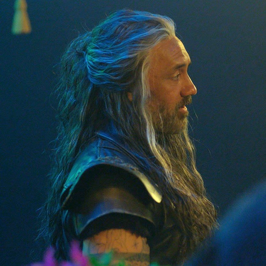 ed teach side profile from calypso's birthday, his hair is half tied up and the light is hitting the silver streaks juuust right