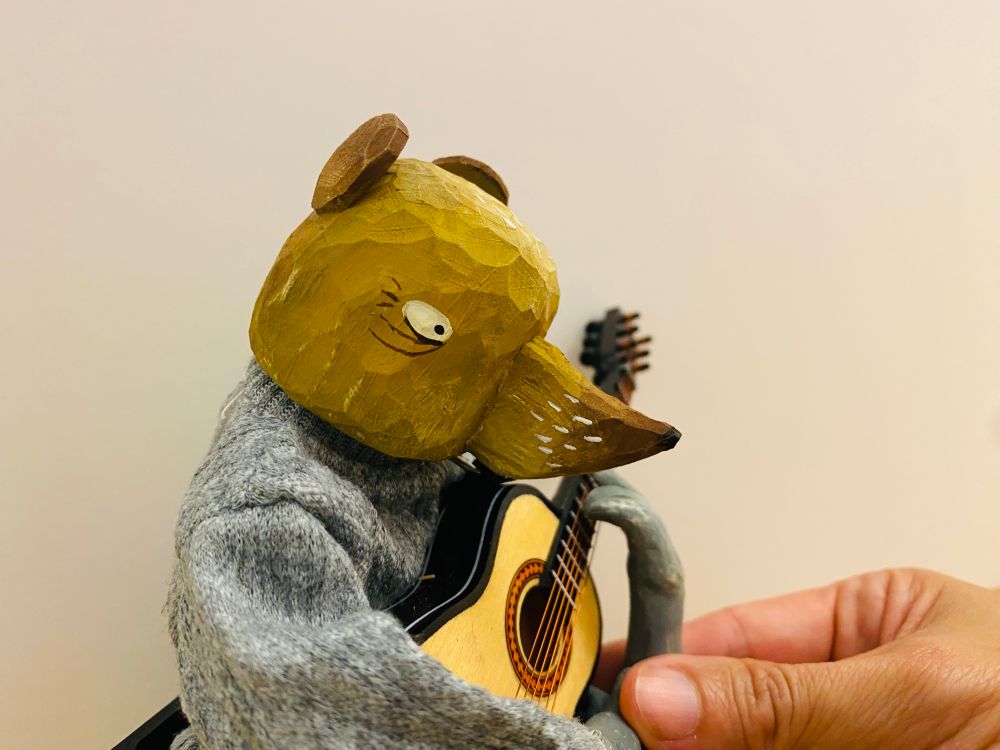 a small rat puppet, playing the guitar