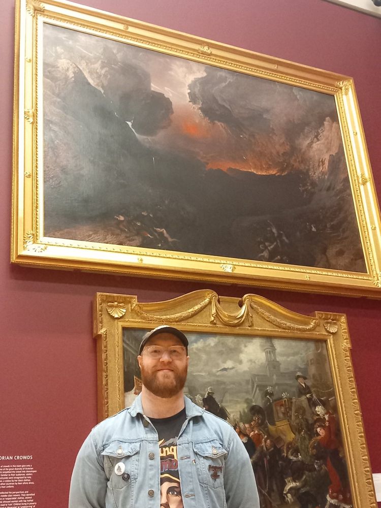 Bald guy in front of John Martin’s The Great Day of His Wrath (1853) at the Tate Britain