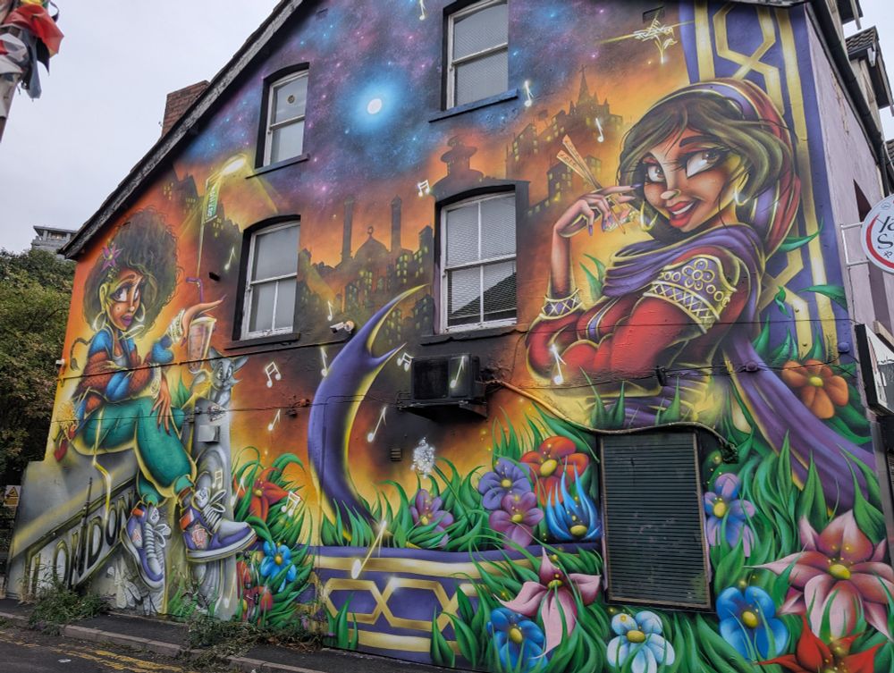 A mural depicting two women in a garden beneath a starry sky. Musical notes float between them.