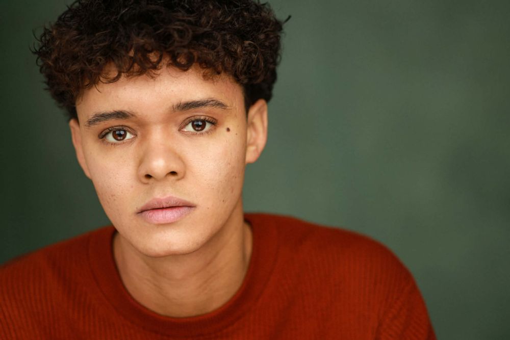 Jax in red sweater against green background