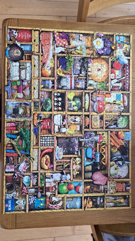 Completed jigsaw of a cupboard crammed full of all sorts of stuff