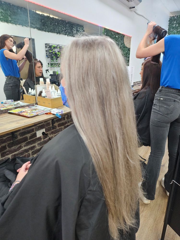 Before picture, sitting in a hairdressers chair with long, light brown hair, halfway down my back, wearing a mask