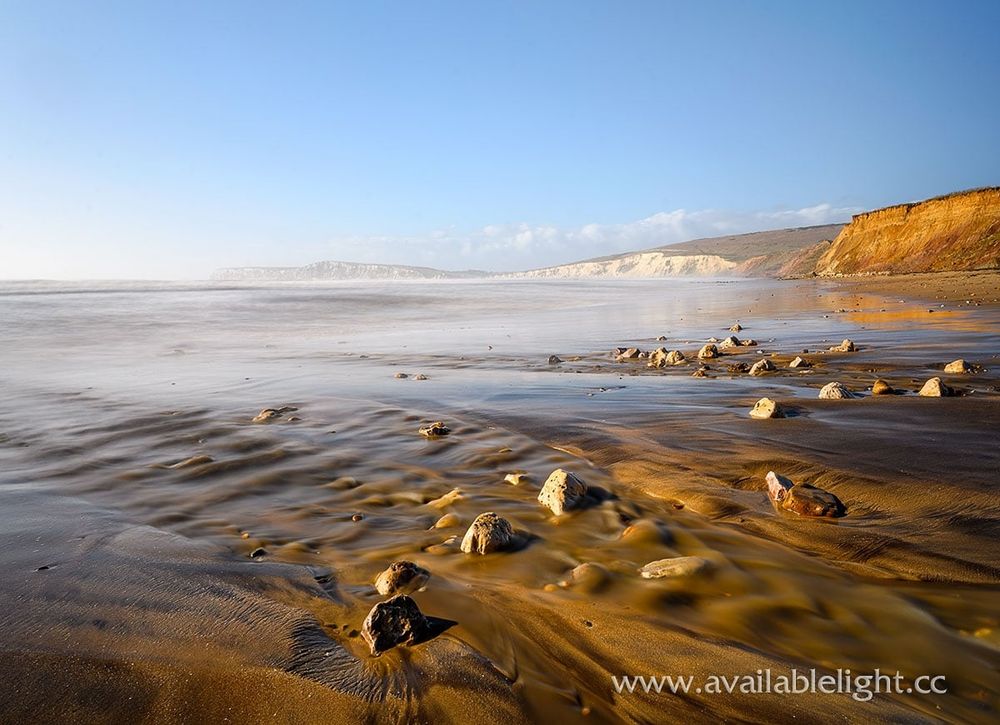 A deserted beautiful beach in the late winter haze. Blue skies, white cliffs in the gentle light.