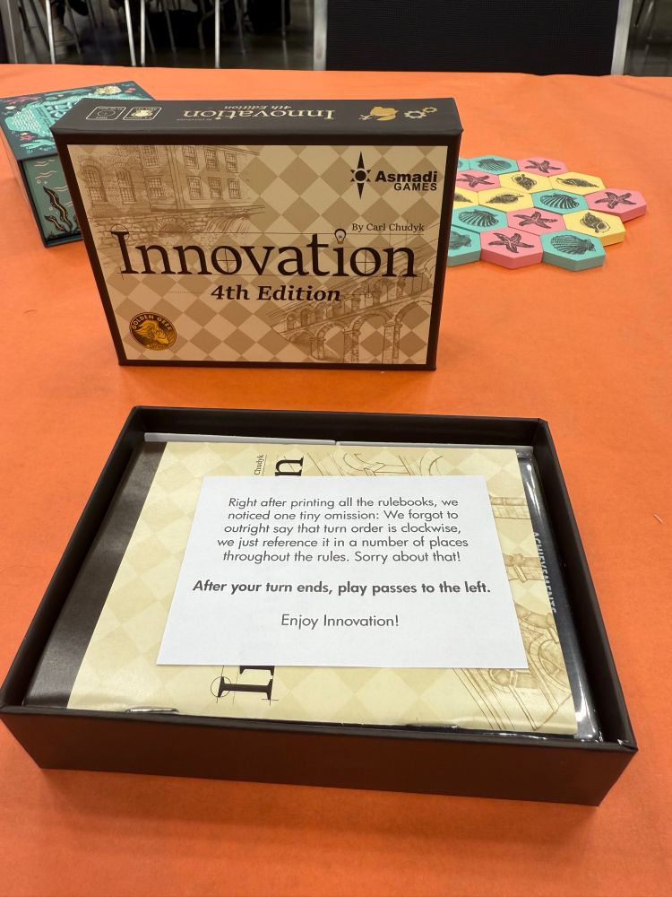 Innovation 4th Edition with a note inside:

“Right after printing all the rulebooks, we noticed one tiny omission: We forgot to outright say that turn order is clockwise, we just reference it in a number of places throughout the rules. Sorry about that!

*After your turn ends, play passes to the left.*

Enjoy Innovation!”