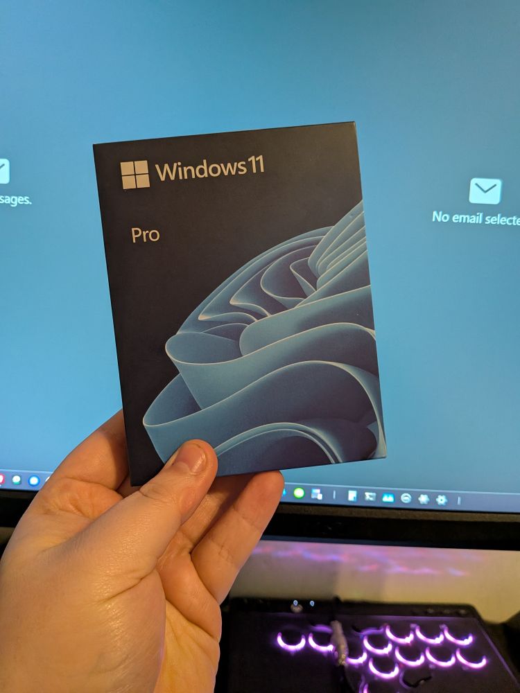 A picture of me holding a boxed USB version of Windows 11 Pro.