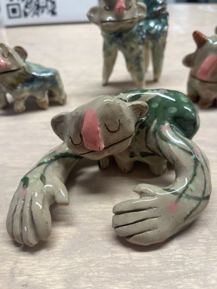 a sleeping creature with large arms. its painted with vines along its body