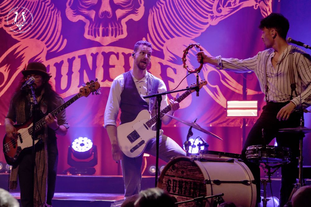 Jeroen standing behind his drum set, with a tambourine in his right hand 