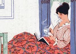 Woman in bed reading whilst holding a cup of tea