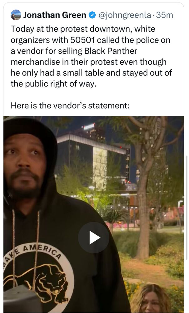Tweet from the bad place. Jonathan Green. Blue check. Text: Today at the protest downtown, white organizers with 50501 called the police on a vendor for selling Black Panther merchandise in their protest even though he had only a small table and stayed out of the public way. Screenshot of a video shows a Black man in a Black Panther sweater at Grand Park in LA, looking… “like wtf?” 