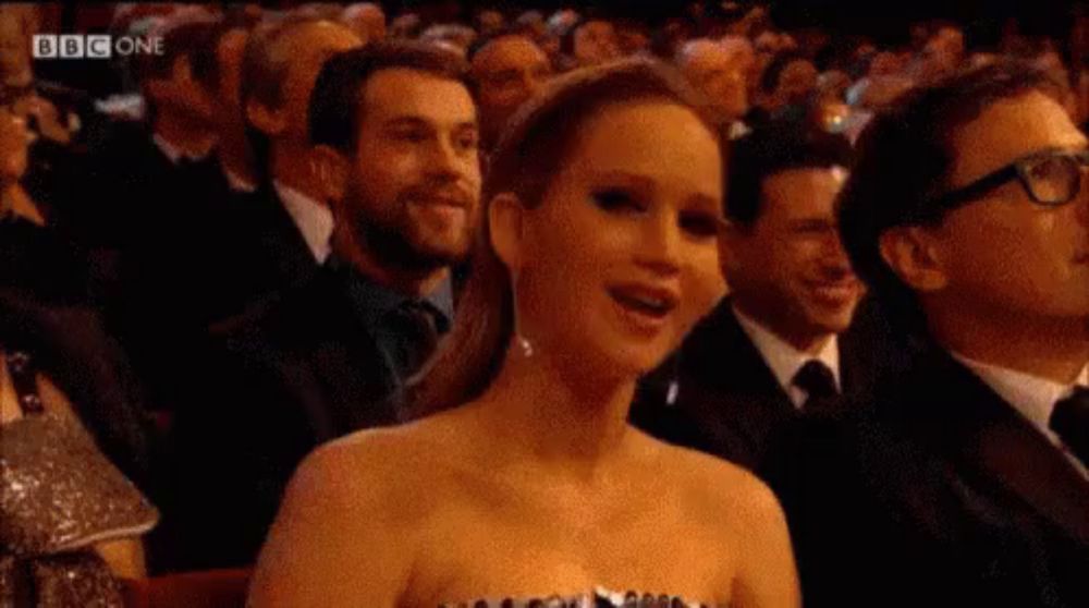 a woman in a dress is sitting in a crowd of people at a awards show .