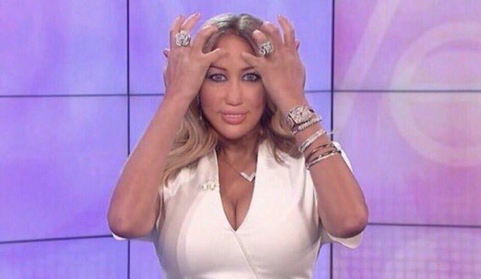 Edit of Wendy Williams with Miley Cyrus’s face. Wendy is wearing a white low-cut top and parting her hair with both of her pinky fingers.