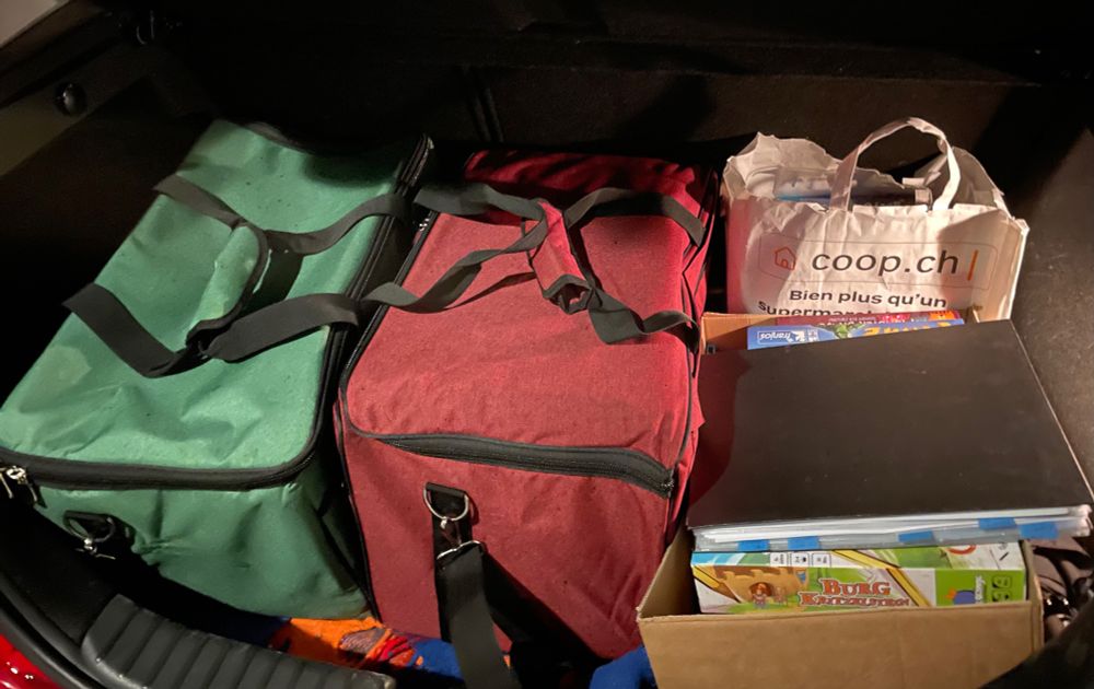 Ein Kofferraum voll mit Brettspielen (in Taschen, Kisten und Tüten). Nur ganz vorne würde noch ein einzelnes Spiel reinpassen, ansonsten ist der Platz optimal ausgenutzt.