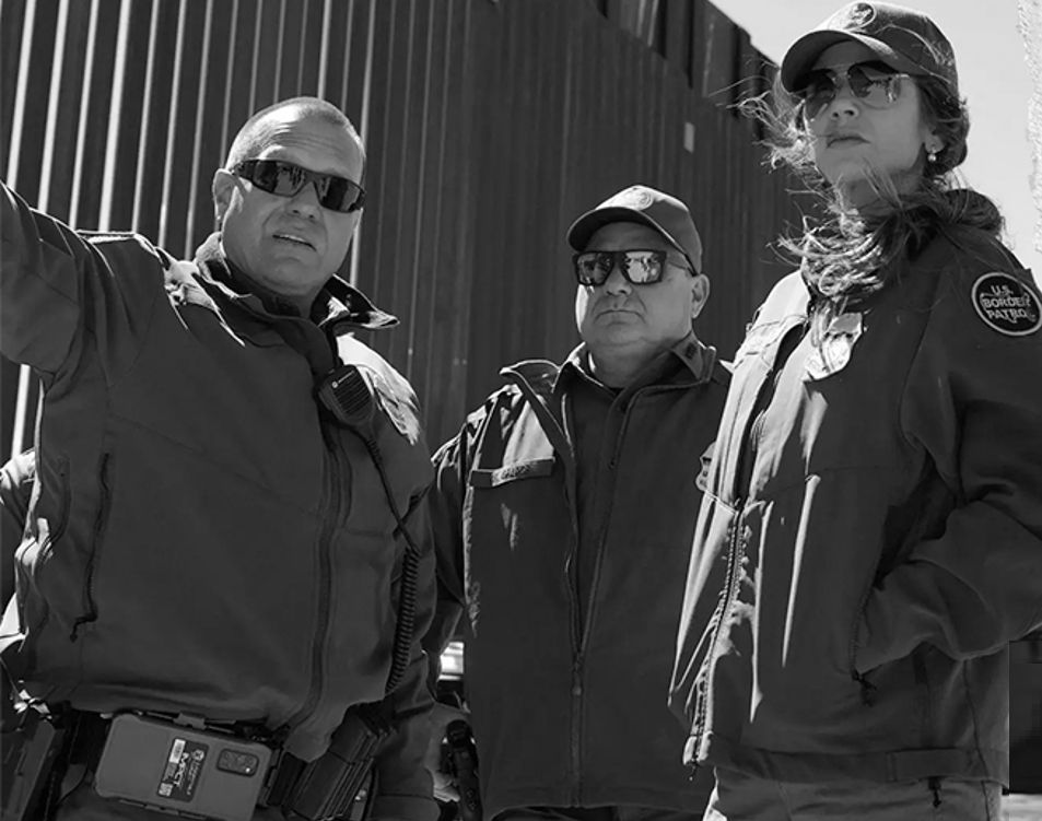 Kristi Noem, who's wearing sunglasses, hangs out at the southern border wall with a couple of law enforcement guys wearing sunglasses. Photo by Alex Brandon. 