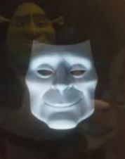 The Magic Mirror from the Shrek 5 teaser. The features of his white, theatre mask-like face are more angular. His chin, cheekbones, and jawline are more pronounced. 