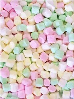 A pile of many small marshmallows in pastels: pink, green, and yellow.