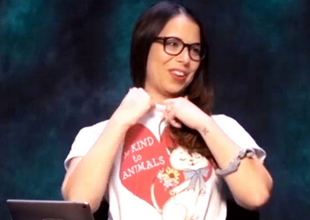 a woman wearing glasses and a shirt that says be kind to animals