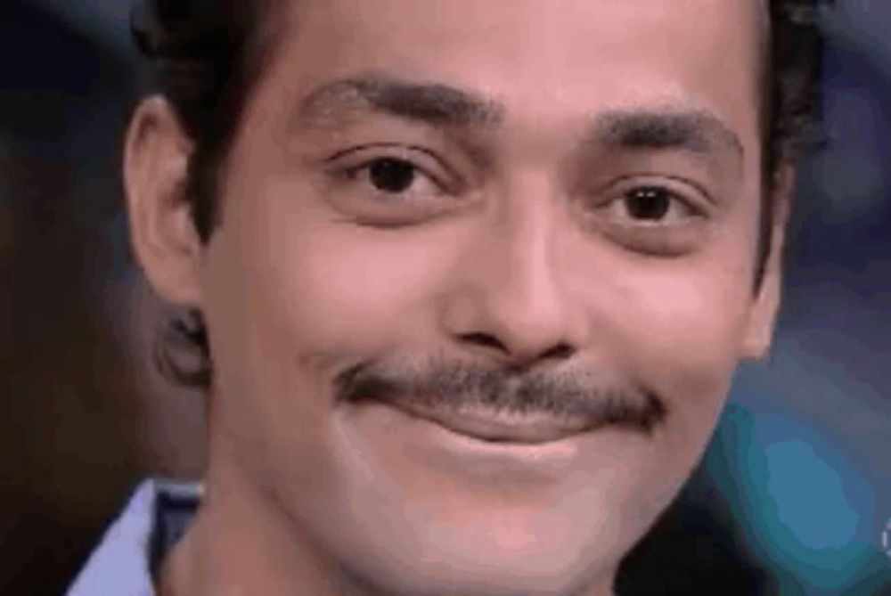 a close up of a man 's face with a mustache making a funny face .