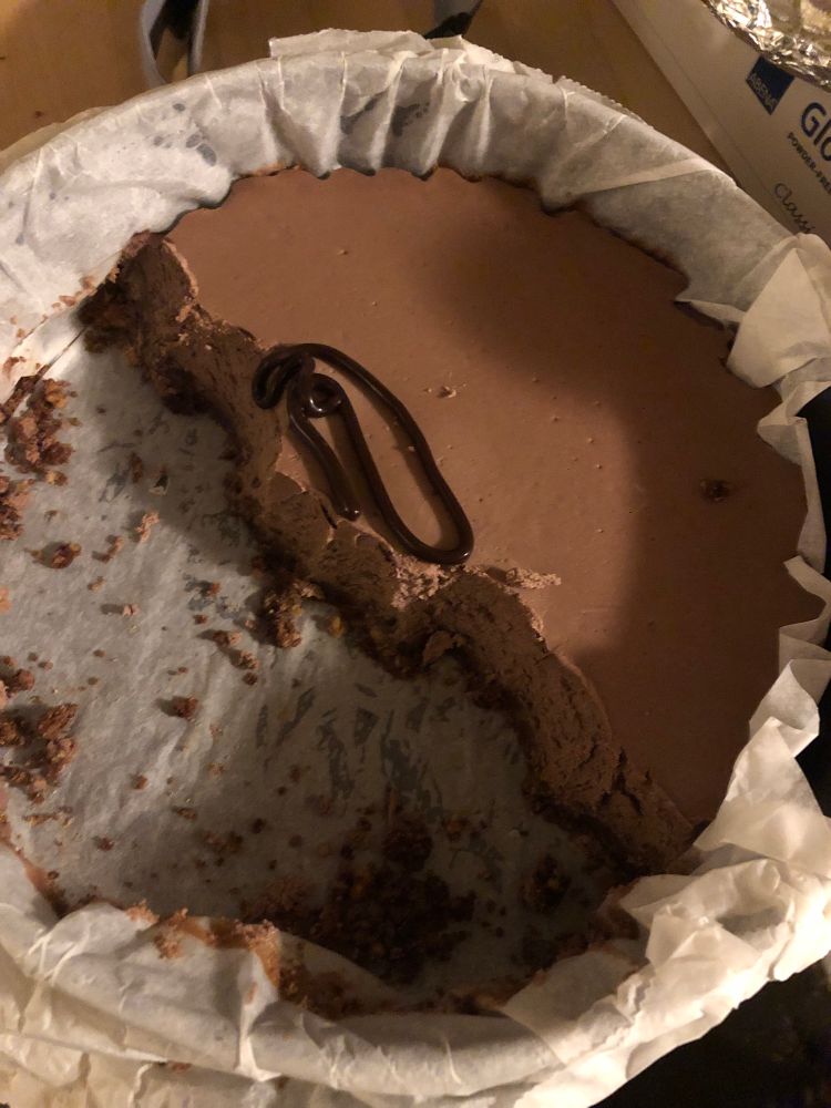 Homemade chocolate cheesecake half eaten from the tin 