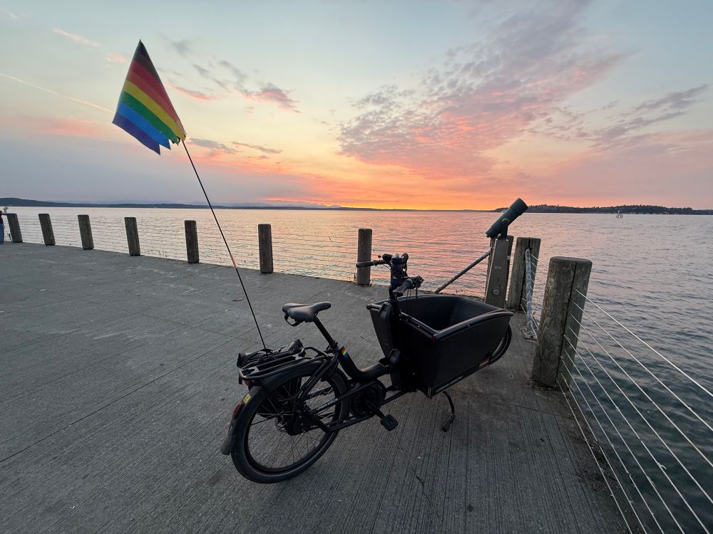Cargo bike on pier with sunset behind 