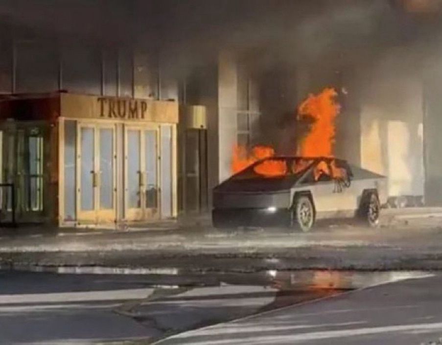 Coche de Tesla ardiendo junto a la puerta del edificio Trump