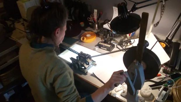 Ulrike Reichhold of Cineric, Inc., one of the foremost film restoration laboratories in the world, at her workbench inspecting a negative prior to repairing and scanning. Photo by Simon Lund, courtesy Cineric.