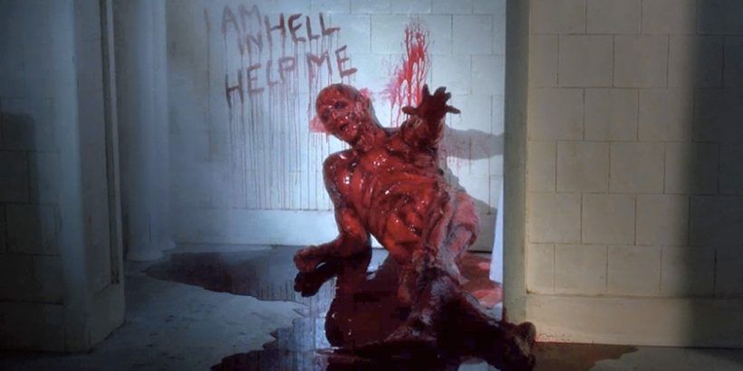 Sean Chapman as Frank Cotton, flayed and bloody, sitting against a tiled wall in a pool of his own blood, I AM IN HELL HELP ME written in blood on the wall beside him