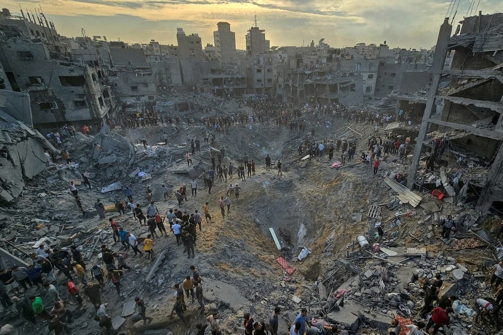 Palestinians search for casualties amid deep craters filled with broken concrete and twisted metal, after Israeli air strikes on the Jabalia refugee camp in the northern Gaza Strip, October 31, 2023. REUTERS/Anas al-Shareef 