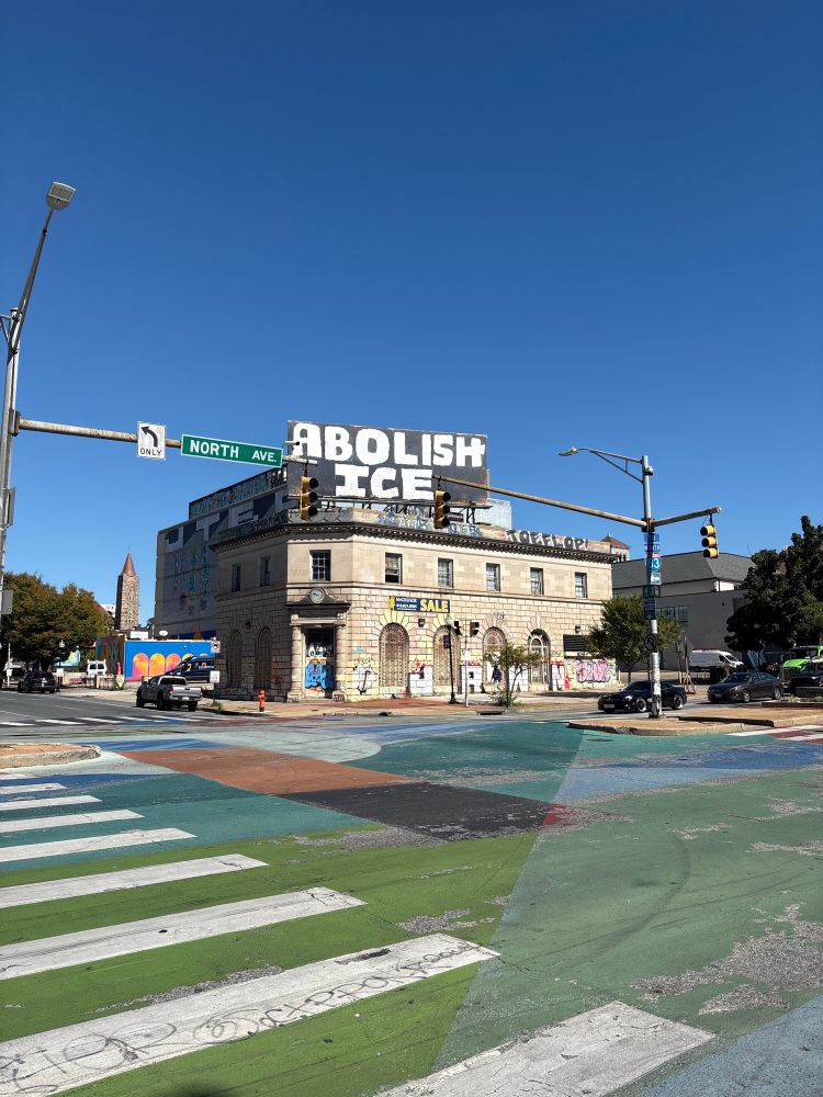 Corner of North Ave. and Charles St. in Baltimore with a billboard saying “ABOLISH ICE”