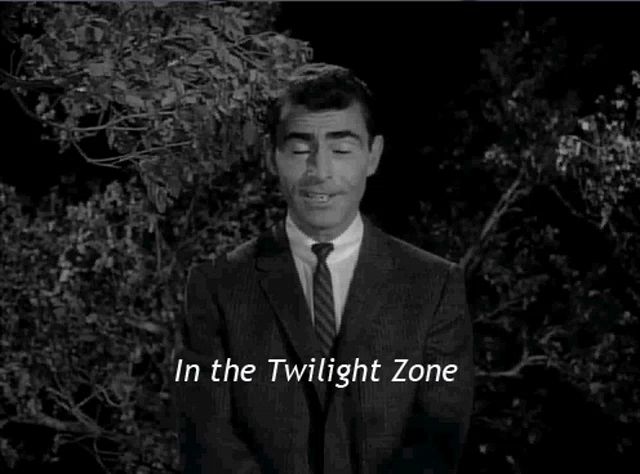 a man in a suit and tie is standing in the twilight zone .