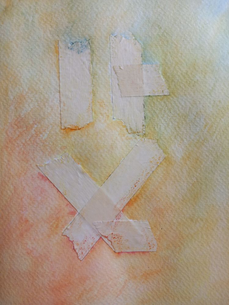 watercolor has been applied around the tape. it's all in one cloud of yellow that mixes with red and with blue in opposite sides.