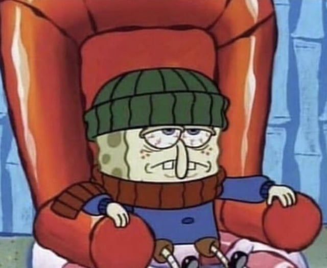 A picture of sick SpongeBob sitting in his living room looking miserable