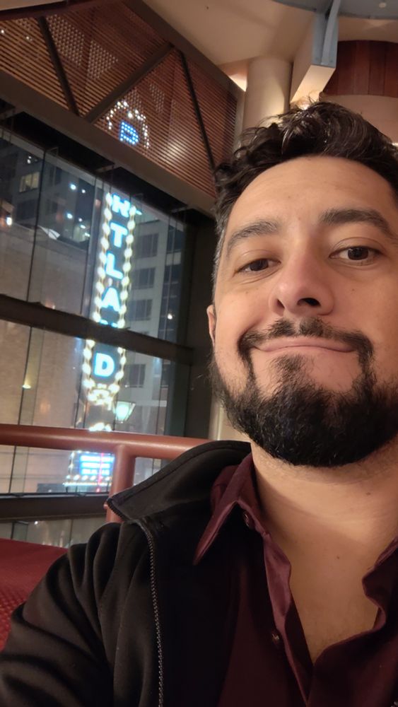 Picture of me in the newmark theater wearing a burgundy button up shirt