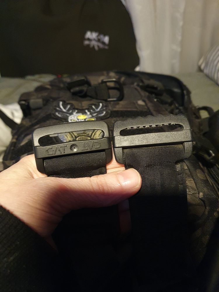 single routing buckle on a real CAT tourniquet on the left says CAT on both left and right side. single routing buckle on a fake tourniquet on the left is plain black.