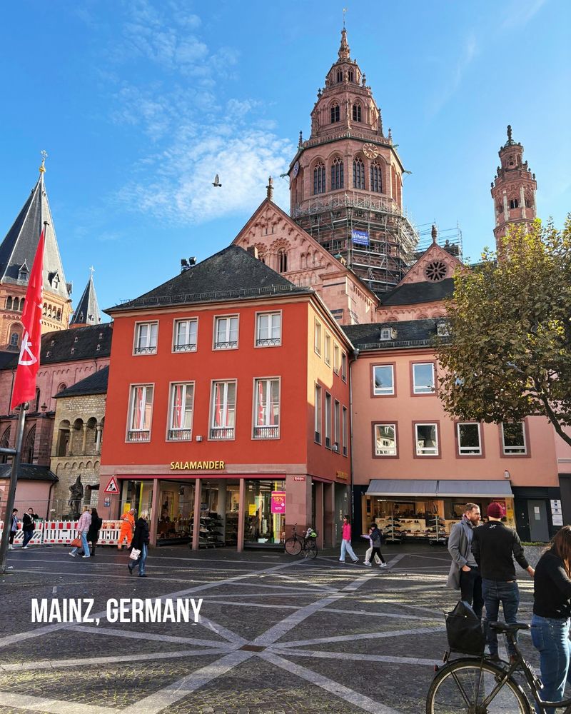 Maing, Germany cathedral behind red and pink buildings in the square