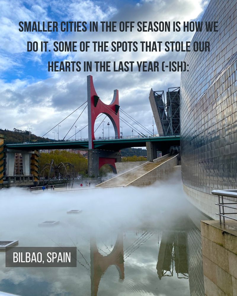 Guggenheim Bilbao with red bridge nearby and reflection in the water