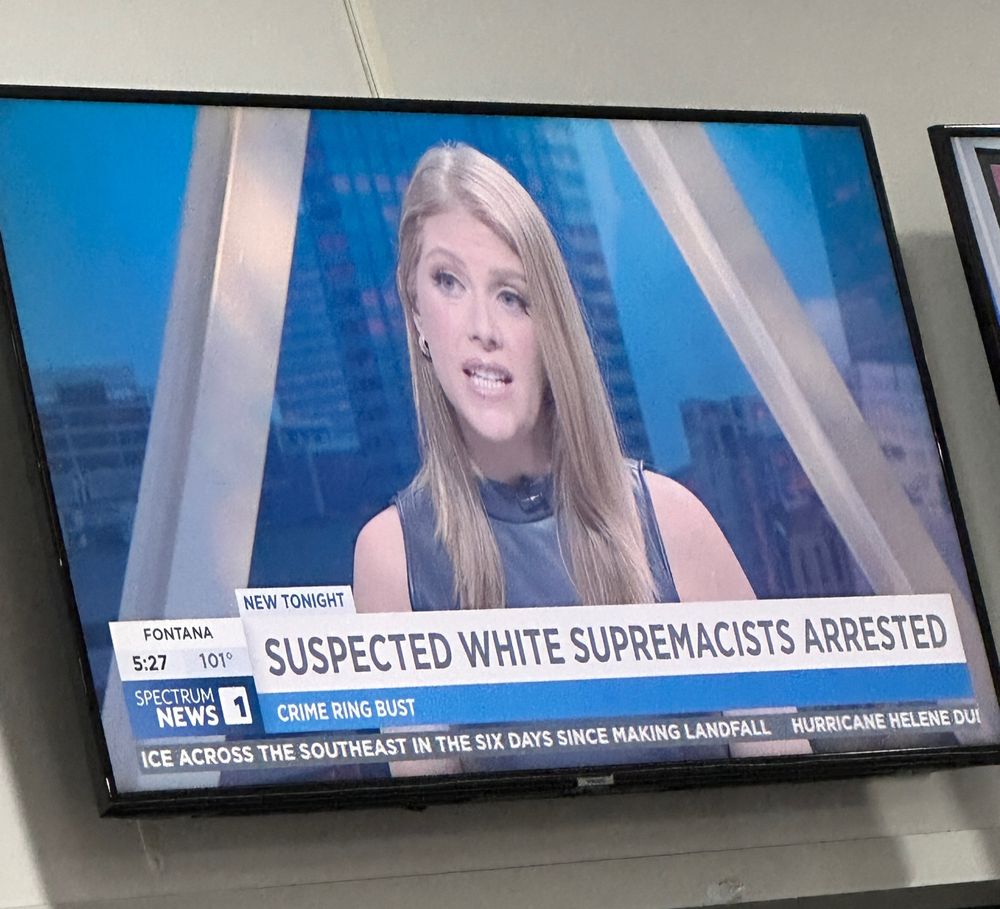 Picture of Kate Cagle talking on a tv screen with the banner “Suspected White Supremacists Arrested”
