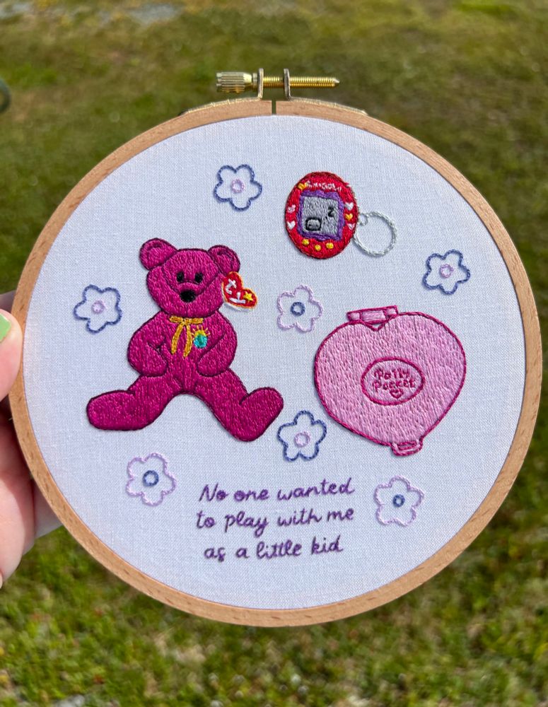 Hand embroidered hoop art of taylor swift mastermind lyrics with nostalgic 90s/2000s toys 