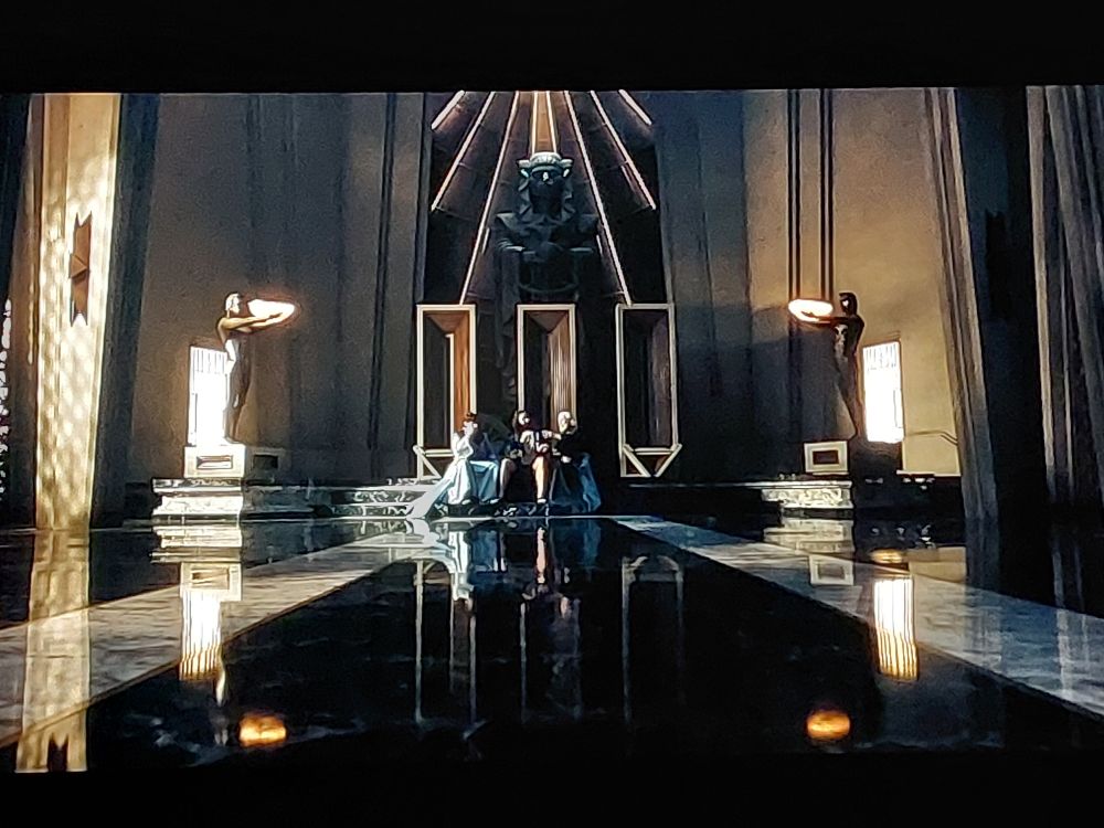 After sharing in an ascension ritual passed down from a previous Cleon, the clones have come together, sitting next to one another at the center, laughing in the distance as the camera moves away.