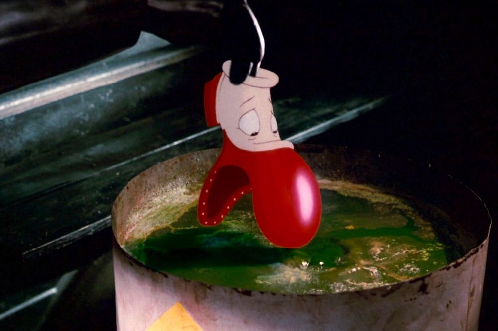 Still from 'Who Framed Roger Rabbit' showing a toon shoe being lowered by a black gloved human hand into a barrel of green bubbling toxic "DIP" which dissolves toons on contact in the film.