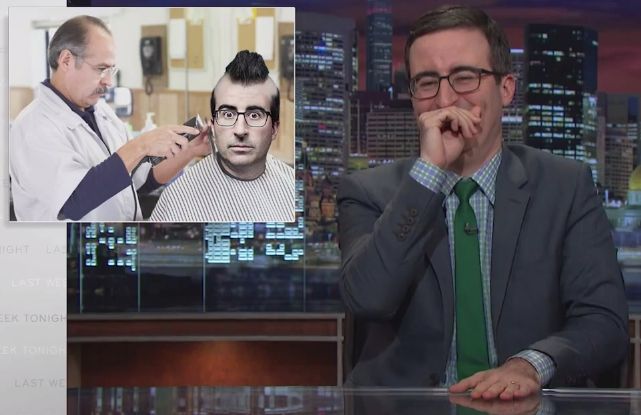 John Oliver laughing at a graphic of John Oliver getting a mohawk haircut from a barber.