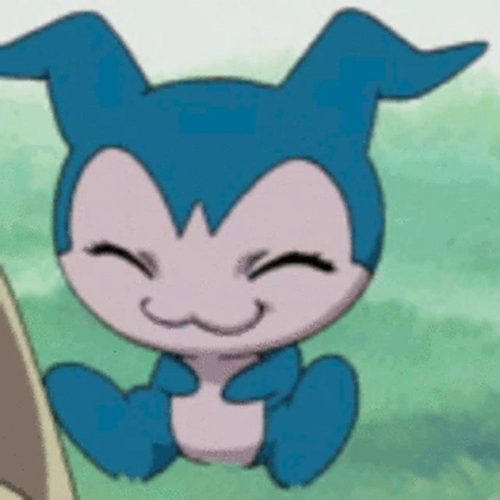 a blue and pink cartoon character is sitting in the grass and smiling .