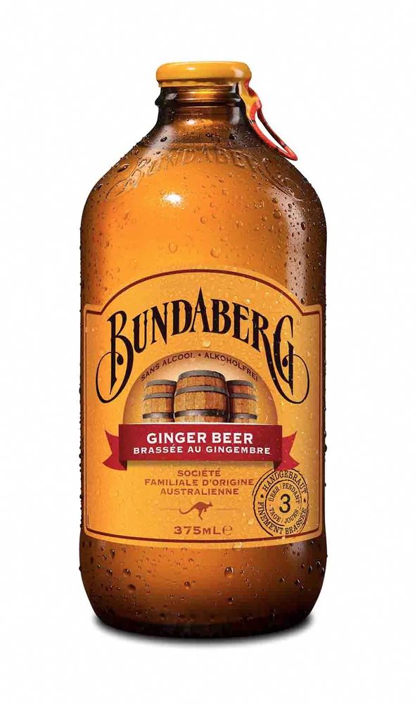A picture of a bottle of Bundaberg brand ginger beer on a white field. The bottle is a warm amber color with a yellow cap. The Bundaberg label is yellow paper with "Bundaberg" written in stylized script above three beer barrels and the words "Ginger Beer" on a red banner. There's some french words I cant read very well, a small logo of a kangaroo, and at the very bottom of the label the mark 375ml
