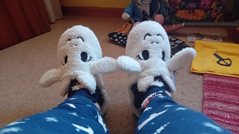 undertale toriel slippers. christmas chill pants. not pictured are jellycat smiley sun plush and undertale human little buddy figure, because i forgot about them before taking the picture.